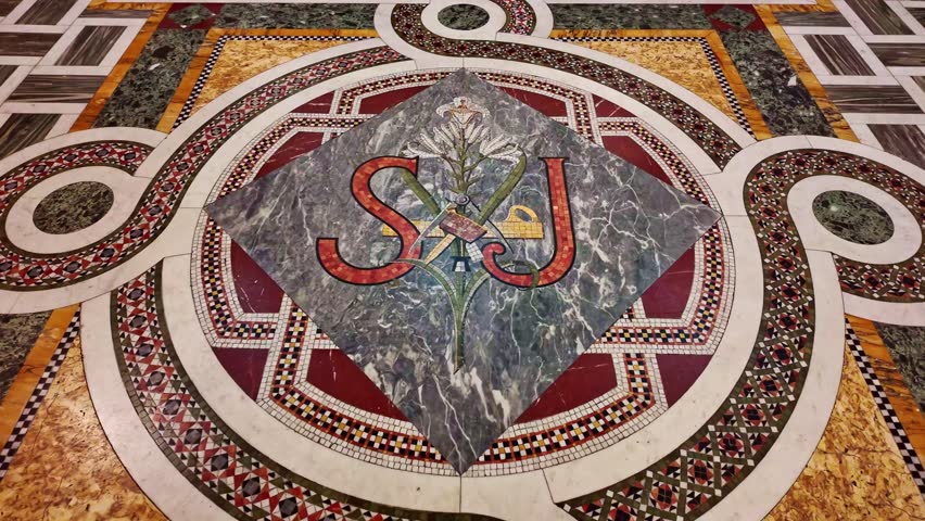 Beautiful marble floor mosaic inside the Sacré-Coeur catholic basilica with religious initials and floral motif, Paris, France.