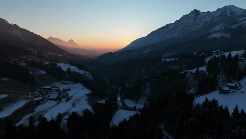 Drone hyperlapse of a colorful sunrise in a quiet valley of the Austrian Alps.