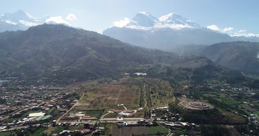 Drone shot of the historic Yungay Cemetery, Peru, with the towering snow-capped Huascarán mountain. A poignant landscape capturing history, nature, and cultural heritage.