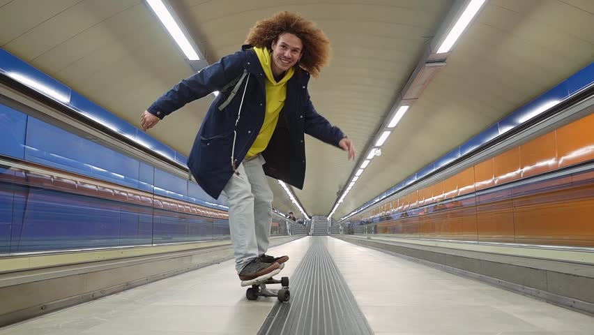 Young skater cruising through subway corridor in slow motion, capturing urban energy and youthful freedom with dynamic, smooth movement