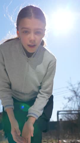 Young girl dances joyfully in her sunny suburban yard, gazing hopefully at future