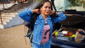 Lady traveler arrives adjusting backpack near parked car, Tourist in rural spot fixes straps before exploring area, Female visitor reaches native place, Expression smiling while talking, Day tripper - Powered by Shutterstock - Get 15% off with code: PIKWIZARD15