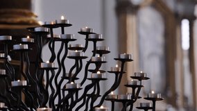 Burning candles on elegant wrought iron candelabrum illuminating church interior - Powered by Shutterstock - Get 15% off with code: PIKWIZARD15