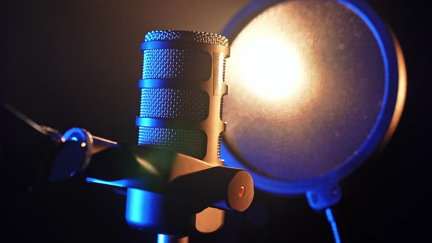 Professional studio microphone with pop filter in dramatic lighting