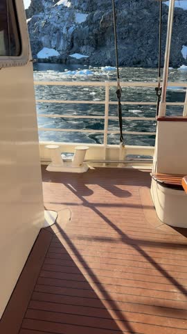 Sailing icy waters ship boat Iceberg glacier sailboat landscape Arctic Antarctica nature winter tourism travel cold ice ocean sea. Cruise traveler expedition adventure concept Vertical view 