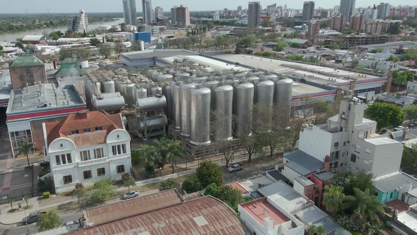 Drone orbiting a large brewery near a river