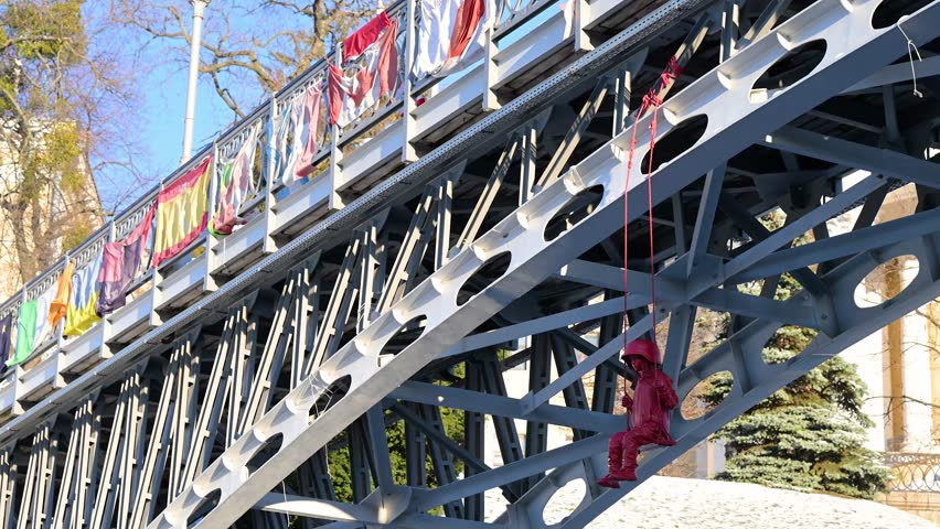 James Colomina’s "Swing" sculpture in Kyiv features a girl in a large military helmet on a swing under a bridge near the Alley of Heroes, close to Independence Square (Maidan Nezalezhnosti), Ukraine.