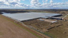 Aerial view of large data centre processing facility glass building expansive countryside flat agricultural land quantum farming sunny day England UK Europe. - Powered by Shutterstock - Get 15% off with code: PIKWIZARD15