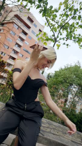 Young Blonde Woman Using Smartphone, Dancing and Enjoying the Moment