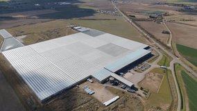 Aerial view of large data centre processing facility glass building expansive countryside flat agricultural land quantum farming sunny day England UK Europe. - Powered by Shutterstock - Get 15% off with code: PIKWIZARD15