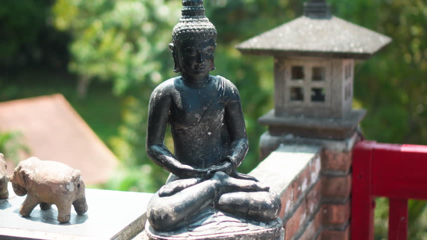 An old hindu stone statue of Buddha standing on the street on the Bali island in indonesia