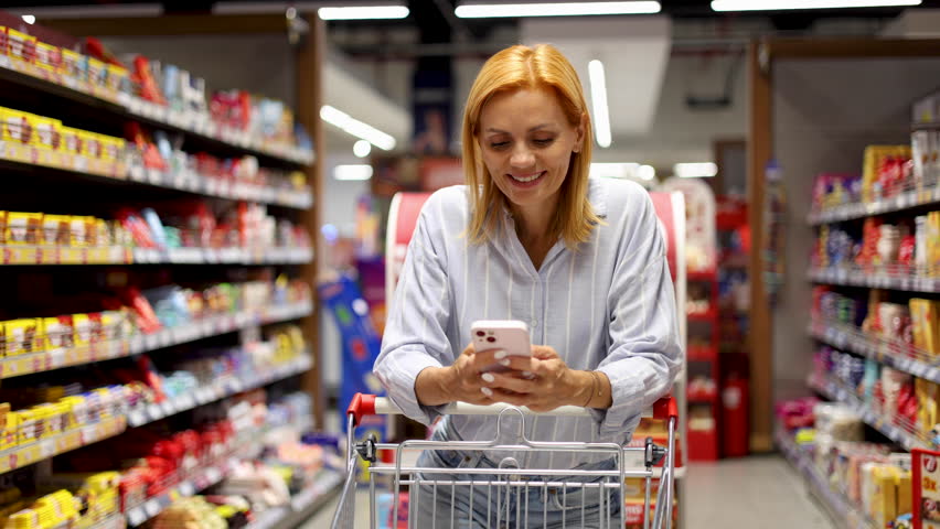 Woman shopping groceries and using smartphone