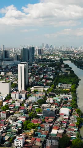 Cityscape: Drone view of modern buildings, hotels, and houses in riverside. Manila, Philippines. Vertical view.