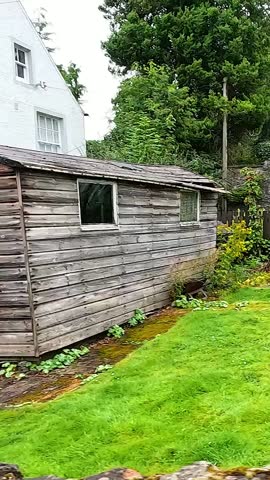 Lush garden with rustic shed and cottage