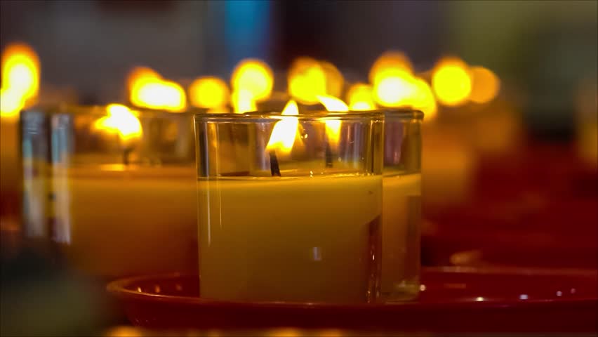 Close-up of multiple lit candles in glass holders placed on red trays creating a warm and serene atmosphere - Powered by Shutterstock - Get 15% off with code: PIKWIZARD15