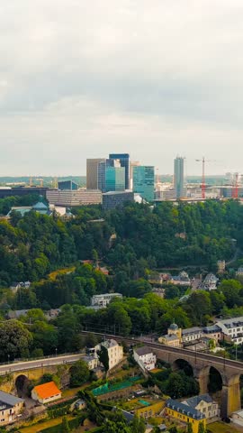 Vertical video. Luxembourg City, Luxembourg. Railway with bridges and arches. View of the Kirchberg area with modern houses, Aerial View. Rich colors