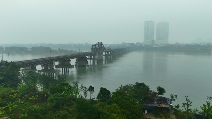 Aerial: Long Bien Bridge with fog and extreme pollution during the day in Hanoi, the capital city of Vietnam, push in drone shot
