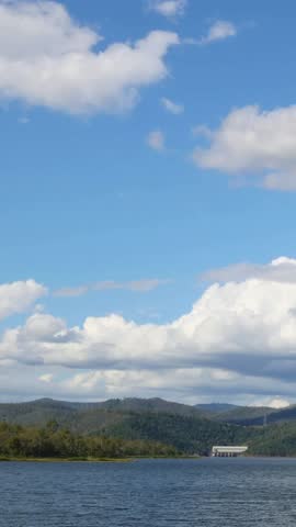 Clouds drift over a tranquil lake and hills