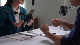 Two podcasters, a man and a woman, are actively engaged in a discussion during a recording session, their expressive hand gestures emphasizing their points - Powered by Shutterstock - Get 15% off with code: PIKWIZARD15