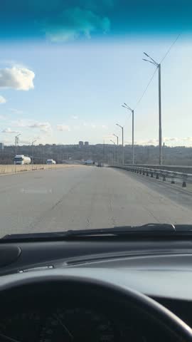 The driver controls the car. First-person video. The driver's hand on the steering wheel. A car ride on a sunny day. Road trips.