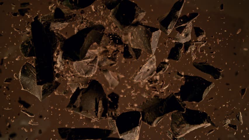 Super Slow Motion of Falling Group of Chocolate Chunks. Moving Down and Splashing into Melted Chocolate. Filmed on High Speed Cinema Camera, 1000fps.