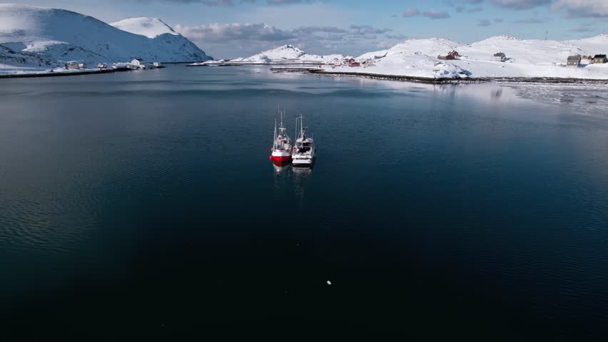 Two fishing vessels moored side by side in open water
