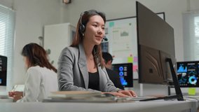 Friendly asian businesswoman wearing headset working as customer service operator attending online meeting with client on computer in modern office, colleagues working in background - Powered by Shutterstock - Get 15% off with code: PIKWIZARD15