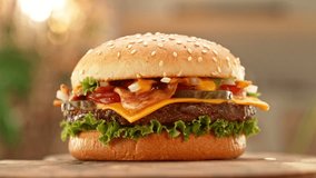 Delicious Hamburger with Cheese in Motion. Fresh Fast Food with Beautiful Bokeh Kitchen Background. Cheeseburger Ready to Eat. - Powered by Shutterstock - Get 15% off with code: PIKWIZARD15