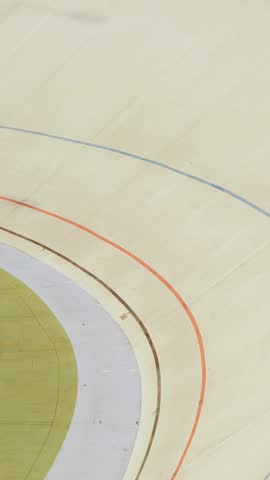 Pursuit track race on velodrome. Professional cyclists racing on cycling track. Outdoor track cycling race. Cyclists on racing track in velodrome, riding fast on bicycles. Vertical video