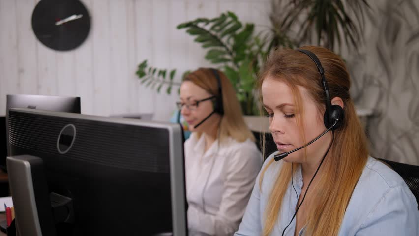 Portrait of an angry annoyed woman in a tech support office, she is talking on a headset with a harmful disgruntled customer. Problems while working in a call center.