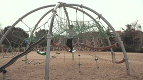 Young boy balancing with concentration on playground climbing structure, showcasing childhood development and urban recreational skills in Madrid park setting - Powered by Shutterstock - Get 15% off with code: PIKWIZARD15