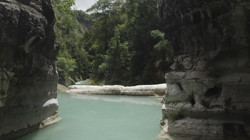 Lost in the beauty of Sumba’s blue river, cradled by majestic cliffs