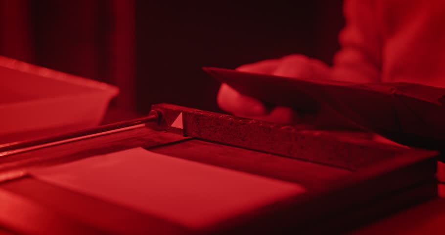 Hands Adjusting Photographic Paper in Enlarger for Film Printing