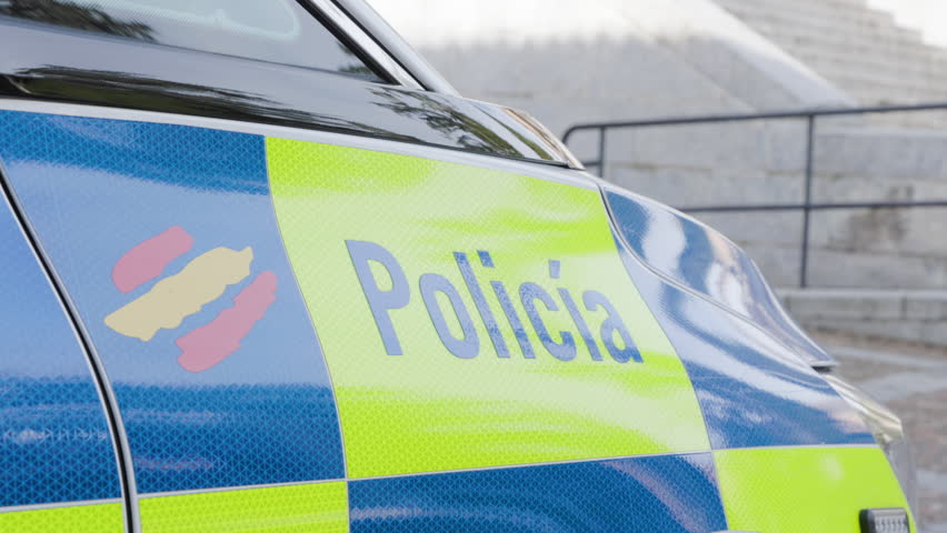 Close-up of a Spanish Local Police Car with Reflective Blue and Yellow Markings and Spanish Flag in Salamanca, Spain