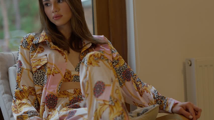 A stylish and talented model strikes an elegant pose in vibrant lounge wear, perfectly showcasing modern fashion trends