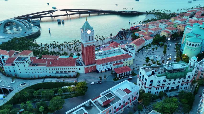Aerial view of a replica of St. Mark's Campanile Clock Tower in the Italian-style City of Phu Quoc Island, Vietnam, with the sunset casting a warm glow over the coastal landscape.
