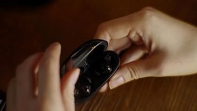 Hand Using Wireless Earphone And Puts To Dock Charging Case. Putting On Before Listening Music. Full Charge Level On Bluetooth Earphone. Portable Device. Puts Wireless Headphones On Charging Case - Powered by Shutterstock - Get 15% off with code: PIKWIZARD15