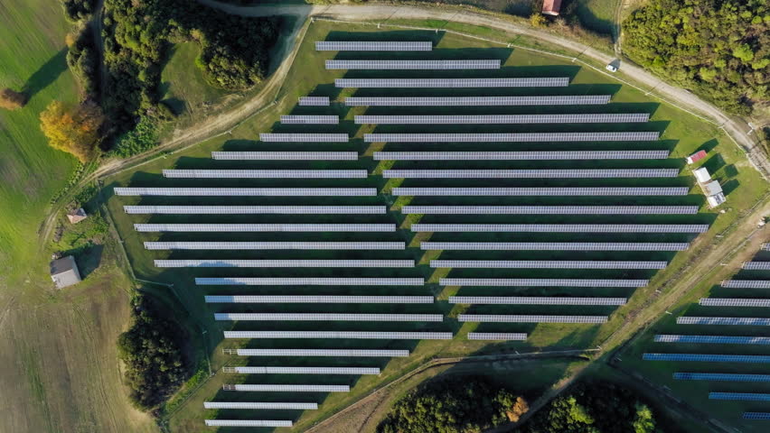 Slow aerial descent reveals a vast array of solar panels at a Greek solar farm, highlighting robust renewable energy infrastructure and modern sustainability.