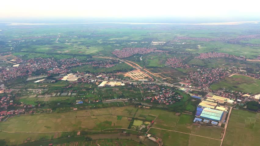 looking down through window of airplane flying over urban Saigon city in Vietnam