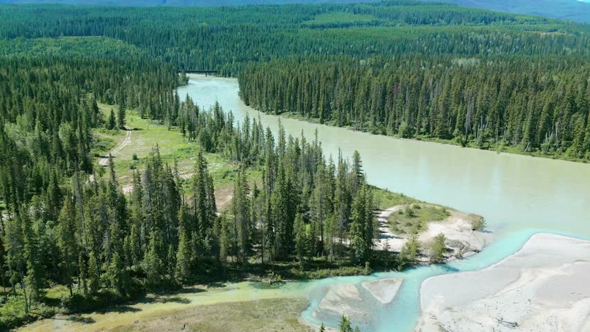 Landscape Of summer  pine forest, The Green Valley in British Columbia Canada. Aerial view footage of river and green forest with mountain natural landscape. drone fly over curve of river and railway