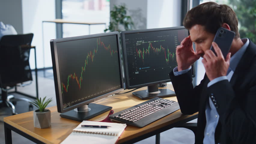 Stressed trader calling cellphone complaining on financial loss at office coworking space closeup. Frustrated broker finish smartphone talk. Depressed investor speaking phone worried stock market data