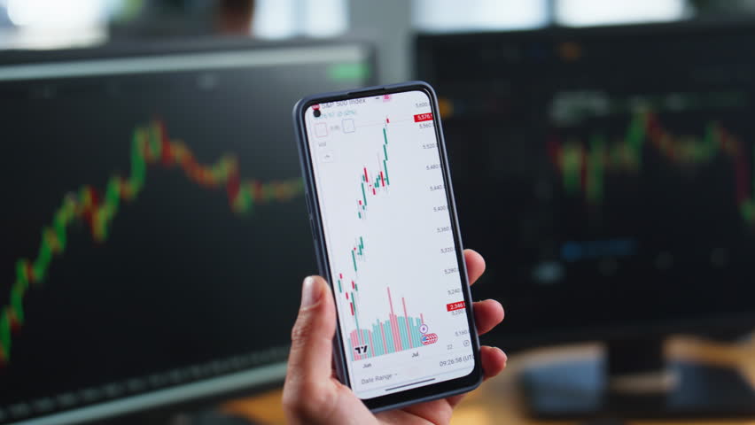 Trader hands holding smartphone displaying financial data of stock trading charts closeup. Unknown businessman analyzing graph currency market. Man broker browsing cellphone app in investing company