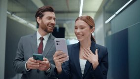 Lady showing smartphone to colleague walking empty hall closeup. Friendly corporate coworkers having work break talking office corridor. Emotional partners looking cellphone together going vestibule - Powered by Shutterstock - Get 15% off with code: PIKWIZARD15