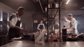 Group of cooking staff busy with dishes preparation at counter - Powered by Shutterstock - Get 15% off with code: PIKWIZARD15