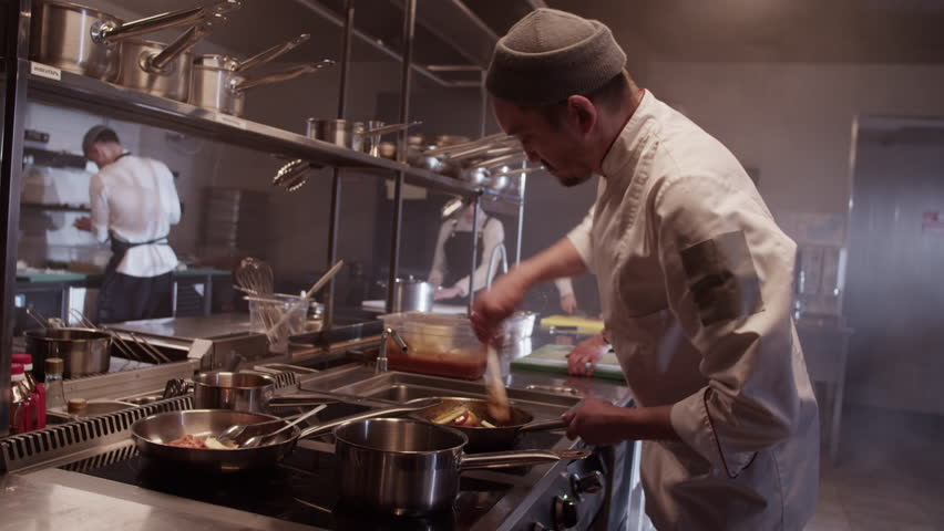 Male cooks working at kitchen counter and preparing food