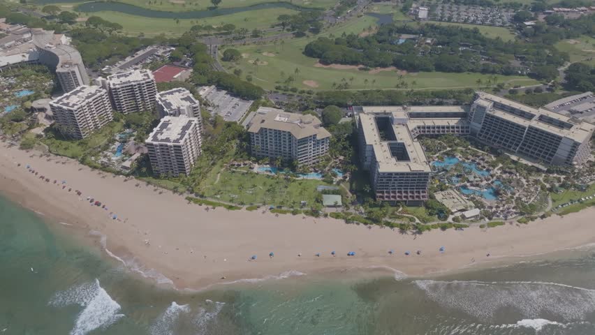 Panoramic view of beachfront hotel resorts pools and golf courses along Kannapali, Hawaii coastline landscape on Maui tropical island - 4K Drone
