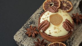 Sweet round tart with white citrus cream and pecans on a dark concrete background - Powered by Shutterstock - Get 15% off with code: PIKWIZARD15