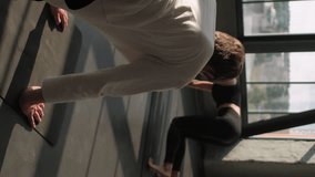 Vertical video. Sport class. Yoga studio. Group people training stretch lesson downward facing dog asana on mat with female coach fitness instructor help correcting pose in gym indoors. - Powered by Shutterstock - Get 15% off with code: PIKWIZARD15