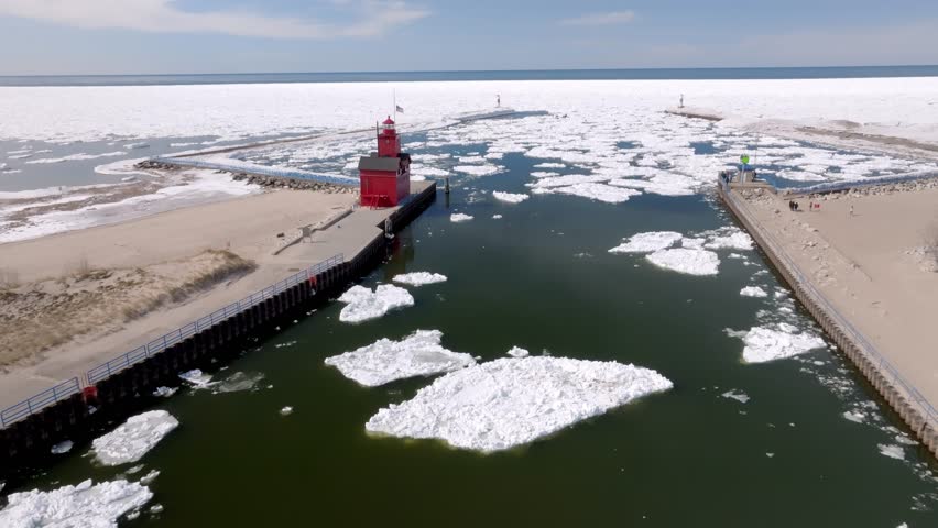 Holland, Michigan lighthouse along Lake Michigan in the winter with stable drone video high.