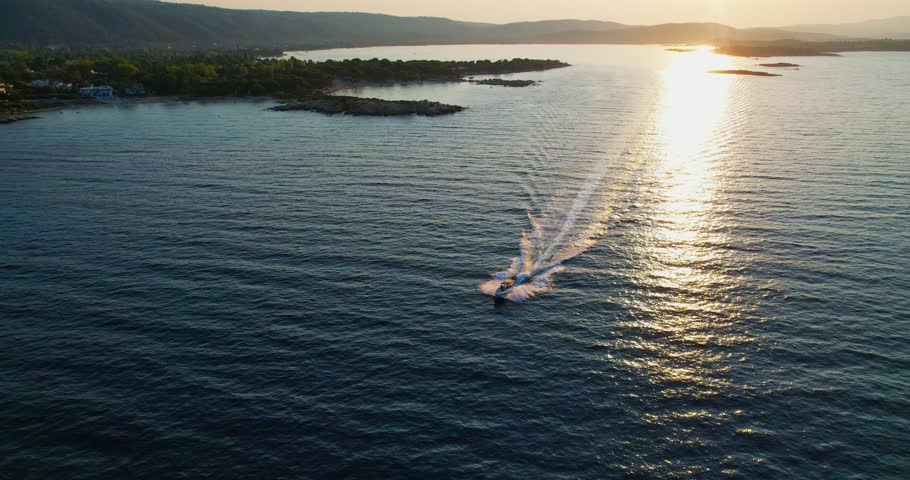 Spectacular sunset over the sea with a boat speeding across the water